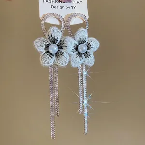 Boucles d'oreilles fleurs en tissu blanc avec perles et longues franges en strass argent