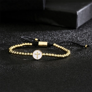 Macro detail of adjustable woven bracelet featuring a gold cross pendant and beads