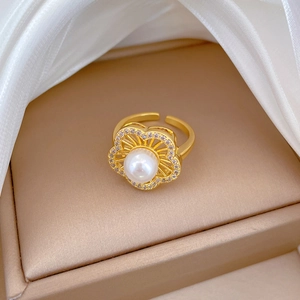 Macro shot of adjustable gold flower ring with pearl center and pavé zircon details