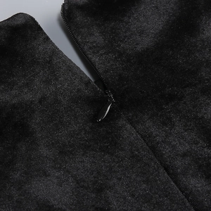 Detailed close-up of the invisible zipper on the black velvet evening dress fabric