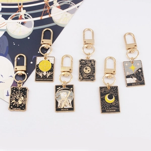 Set of tarot card keychains featuring Sun Moon and Lovers designs in gold and black