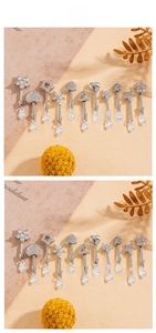 Close-up of titanium steel cartilage studs with heart and teardrop zircon pendants