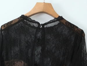 Close-up of the high neck black lace top with a rear button closure and floral pattern