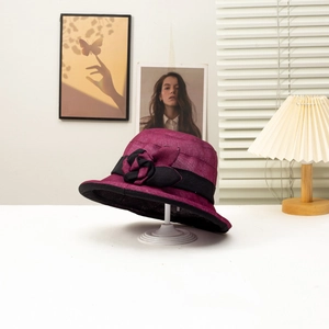 Detail of rose red summer cloche hat with black ribbon bow and woven texture on stand