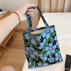 Detailed shot showing the floral jacquard handbag holding a tablet in a cozy room