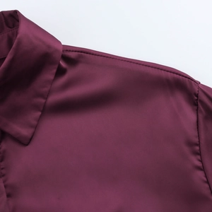 Close-up of wine red satin shirt featuring lapel collar and smooth fabric texture