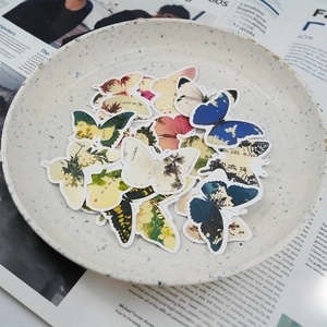 Detailed view of vintage butterfly stickers with diverse patterns on a textured ceramic plate