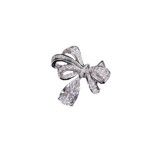 Elegant silver bow ring featuring sparkling diamonds and a pear-shaped drop stone