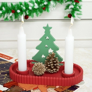 Close-up of a festive Christmas candle tray with two candles and a green wooden tree