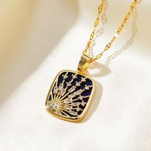 Macro shot of gold sunburst pendant with blue enamel and cubic zirconia on silk