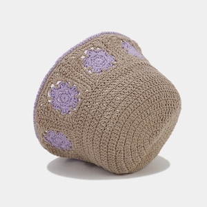Detailed close-up of hollow crochet texture and lavender floral embroidery on tan bucket hat