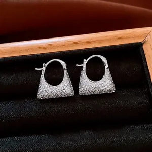 Vintage zircon handbag charm earrings in silver finish on a black velvet jewelry tray