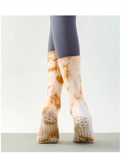 Nahaufnahme der Silikon-Antirutschsohle an orange-weißen Batik-Yogasocken für Damen