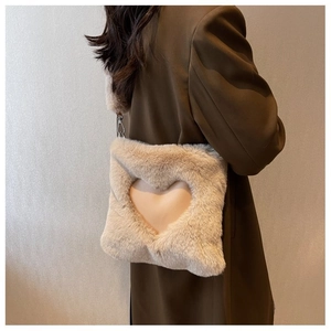 Dettaglio della borsa a tracolla in peluche beige con cuore e catena metallica