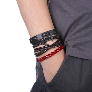 Gros plan d'un ensemble de bracelets multicouches pour hommes avec cordon et ancre