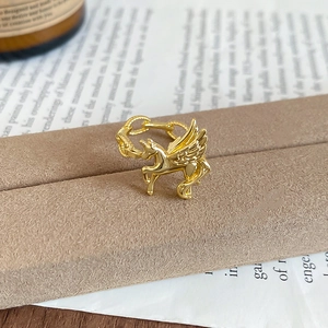 Macro view of gold Pegasus ring featuring zircon wings and chain link band design