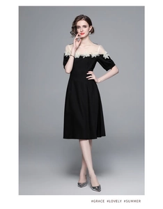 Détail du décolleté en tulle avec fleurs 3D appliquées sur une robe midi noire