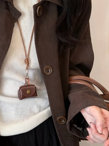 Detail of the vintage brown leather coin purse necklace with woven rope and snap button