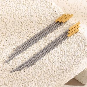 Detail of 18K gold plated geometric bars with textured silver fringe chains on stone