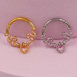 Detail of snake earrings and nose rings with pink heart gemstones in gold and silver