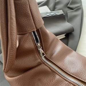 Brown leather dumpling bag with pleated detail and silver zipper for minimalist casual style
