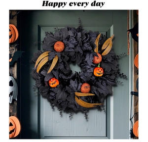 Detail of Halloween door wreath with black maple leaves, orange pumpkins and golden feathers