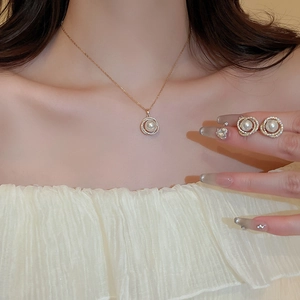 Détail de l'ensemble collier et boucles d'oreilles doré avec perles et zircons