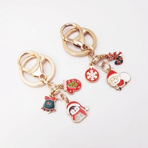 Close-up of festive Christmas metal keychains with Santa Claus and penguin charms
