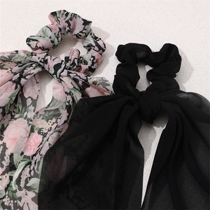 Close-up of pink floral and black chiffon hair scrunchies with long bow ribbon ties