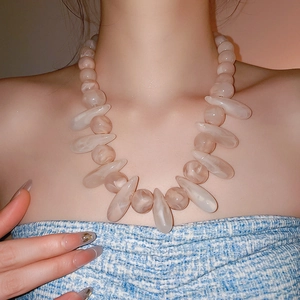 Close-up of pink translucent resin beaded necklace in a bohemian drop design