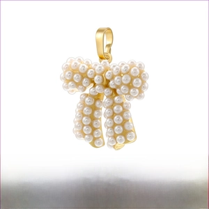 Macro detail of gold-plated brass bow pendant VD1477B1 with inlaid white pearls