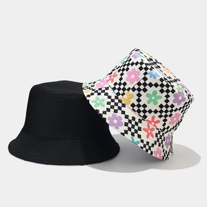 Détail du motif floral à damier et du tissu en coton noir sur des chapeaux bob réversibles
