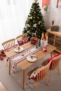 Close-up of modern Christmas table runner and pillow featuring reindeer and snowflake prints
