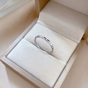 Detailed macro of a silver titanium steel ring with inlaid crystals in a jewelry box