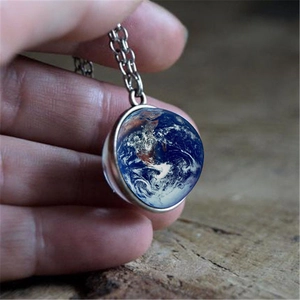 Silver-edged necklace featuring a double-sided earth globe glass pendant on wood background