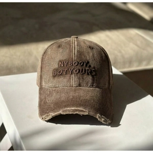 Close-up of vintage washed cotton baseball cap with NYBOOY embroidery and distressed brim