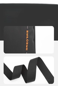 Detail of orange embroidered logo on black shoulder bag with high-density nylon strap