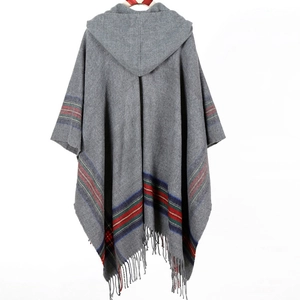 Back view of a grey striped knit poncho featuring a hood and fringe hem detail