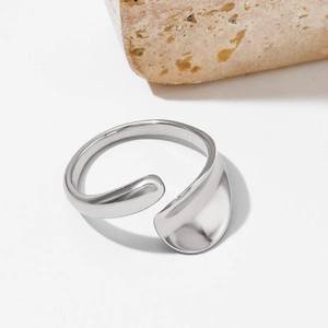 Minimalist irregular open ring in polished silver finish on a natural stone background