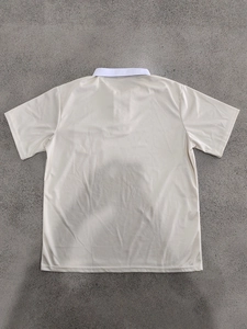 Flachliegende Rückansicht eines Herren-Polo-Shirts in Beige mit Farblock-Design und Textur