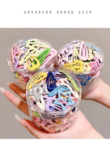 Three jars of colorful star and oval hair clips held by hand for kids hair accessories