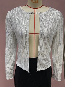 Detail shot of shimmering silver sequins and round neckline on a cropped jacket