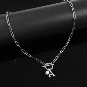 Detail view of silver paperclip chain necklace with letter A pendant and white pearl