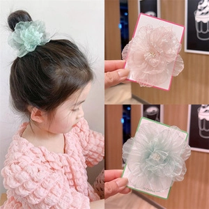 Detail of pink and mint green organza flower hair ties for girls on card packaging