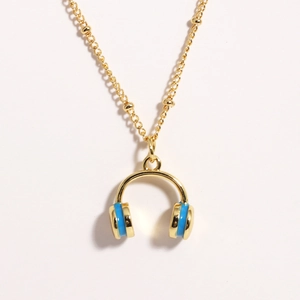 Close-up of golden headphone pendant with blue enamel on a bead chain necklace