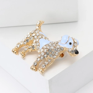 Detail of golden dog brooch with sparkling rhinestones and light blue enamel coating