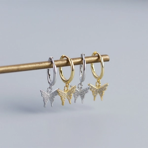 Close-up of S925 silver butterfly hoop earrings with sparkling crystals in gold and silver