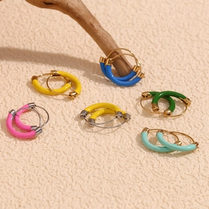 Close-up of colorful enamel hoops in pink, yellow, blue and green on a minimalist base