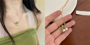 Detail of lily of the valley pendant necklace featuring gold chain and enamel flowers