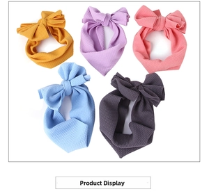 Flat lay of five baby bow headbands in yellow, purple, pink, blue, and grey waffle fabric